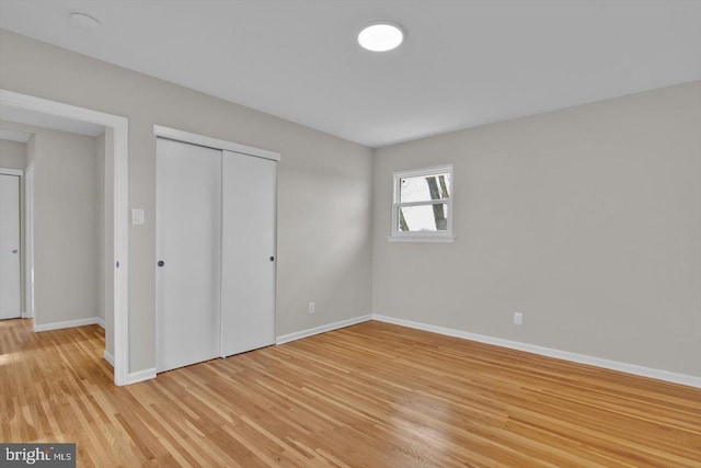 unfurnished bedroom featuring a closet and light wood-type flooring