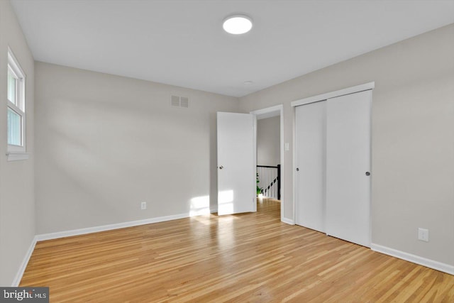 unfurnished bedroom featuring light wood-type flooring and a closet