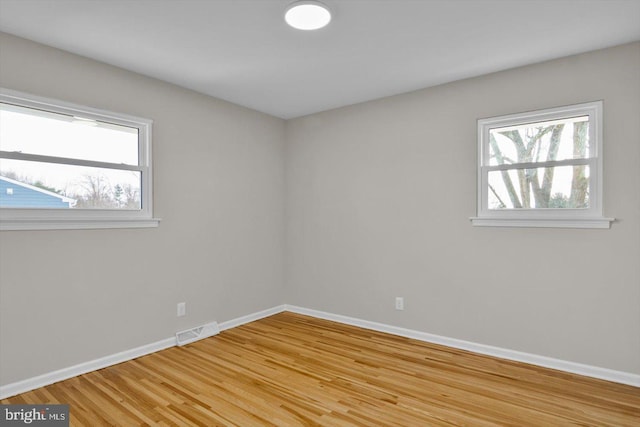 unfurnished room with plenty of natural light and light hardwood / wood-style flooring