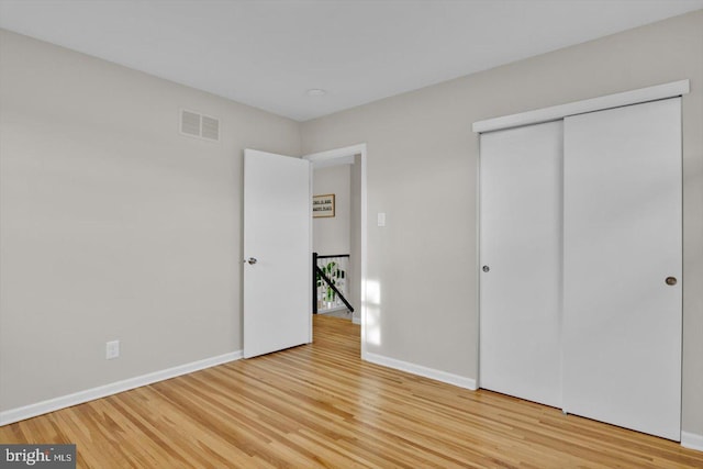 unfurnished bedroom featuring a closet and light hardwood / wood-style flooring