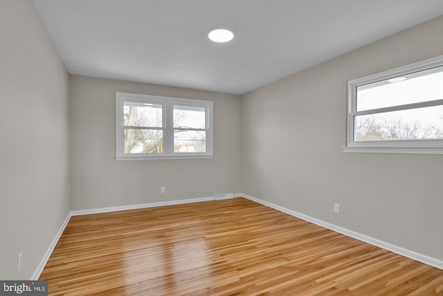 unfurnished room featuring plenty of natural light and light hardwood / wood-style floors