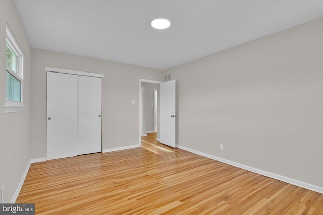 unfurnished bedroom featuring a closet and light wood-type flooring