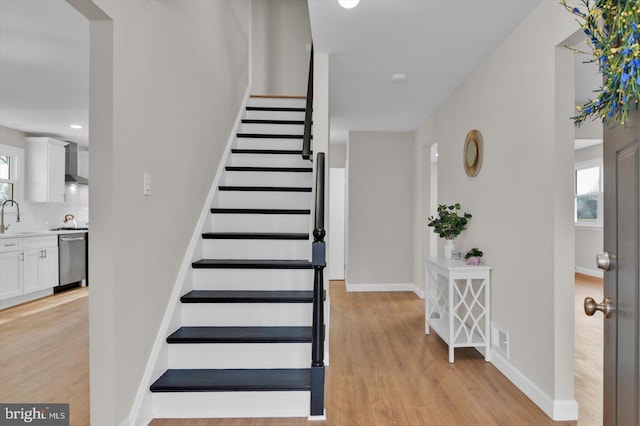 stairway featuring sink and hardwood / wood-style flooring