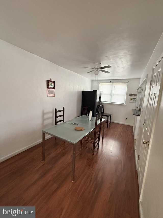 dining area with dark wood-type flooring and ceiling fan