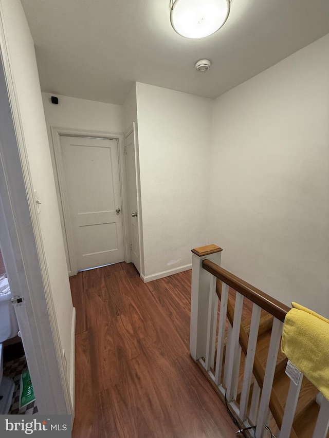 hallway with dark hardwood / wood-style flooring