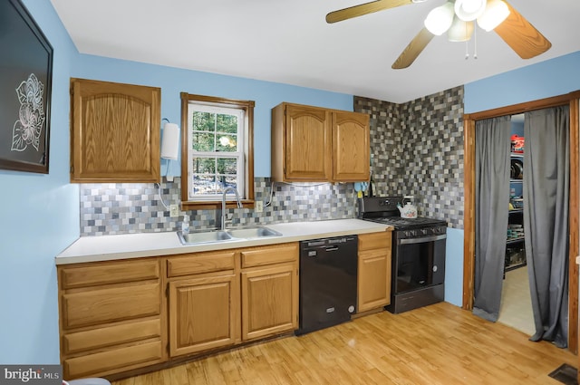 kitchen featuring sink, light wood-type flooring, black dishwasher, range with gas stovetop, and backsplash