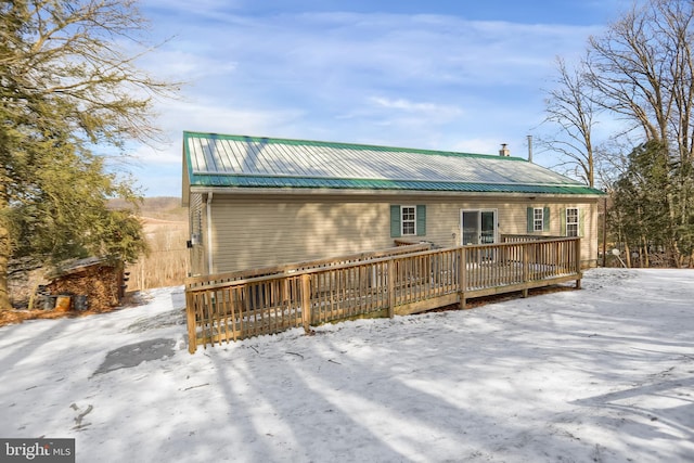 snow covered house featuring a deck