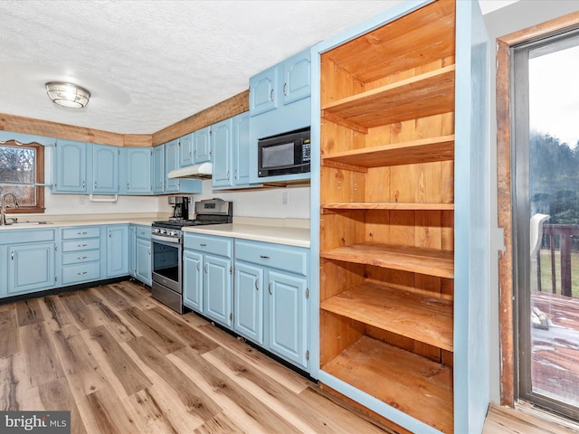 kitchen with sink, stainless steel gas range oven, and blue cabinets