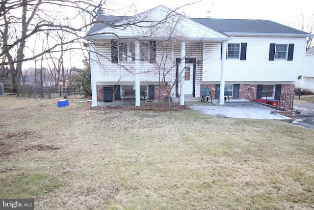 raised ranch featuring a front lawn and a patio