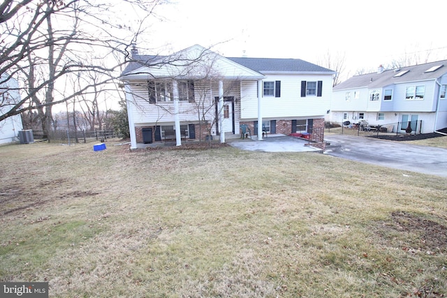 bi-level home featuring central AC unit, a patio area, and a front lawn