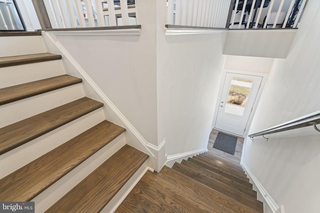 stairway featuring baseboards and wood finished floors