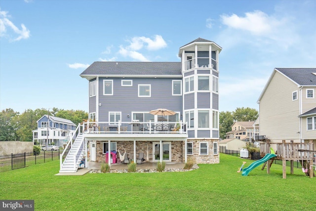 rear view of property featuring a playground, stairs, a yard, a patio area, and stone siding