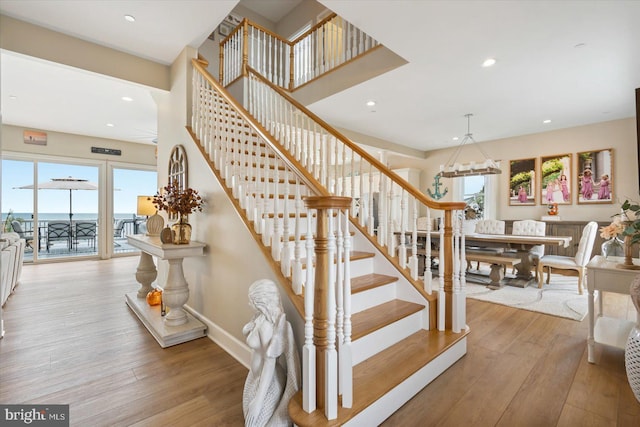 stairway featuring plenty of natural light and hardwood / wood-style floors