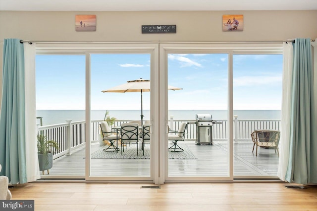 doorway with wood finished floors and a water view