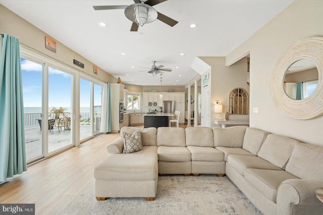 living room with ceiling fan and light hardwood / wood-style flooring