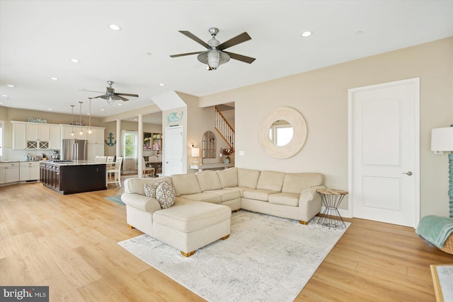 living room with ceiling fan and light wood-type flooring