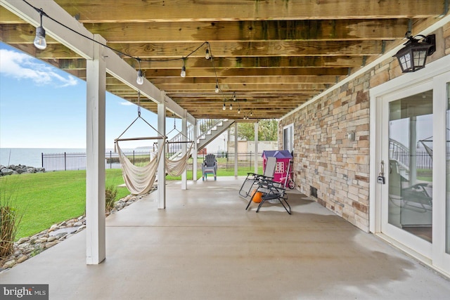 view of patio / terrace with a water view and fence