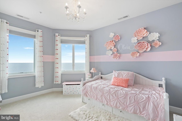 carpeted bedroom with an inviting chandelier and a water view