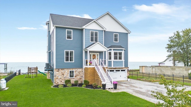 view of front of property featuring a garage, central AC, a front yard, and a water view