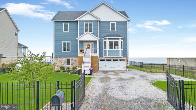 view of front of home with a water view, a garage, and a front lawn