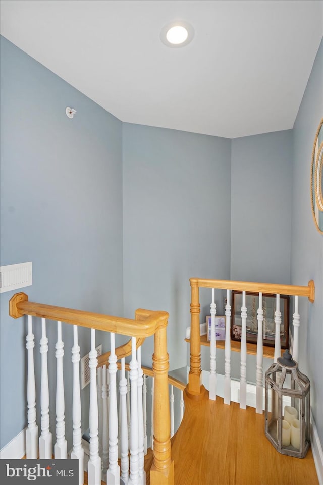 stairway with baseboards and wood finished floors