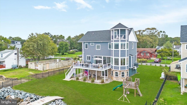 rear view of house featuring a wooden deck, a patio area, a playground, and a lawn