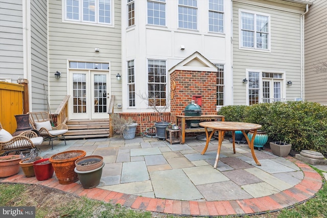 view of patio with entry steps, french doors, and fence