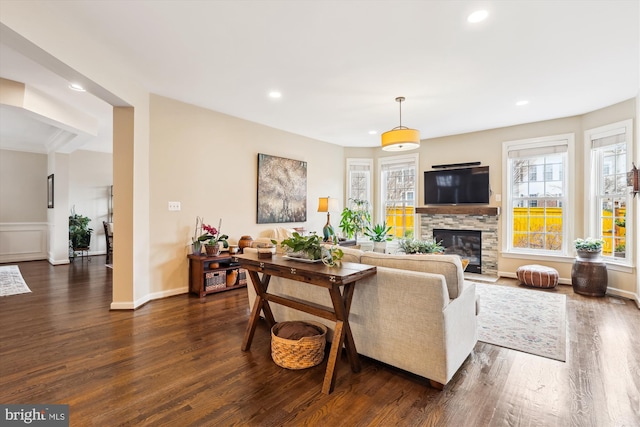 living room featuring recessed lighting, a fireplace, dark wood-type flooring, and baseboards