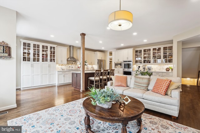 living room featuring recessed lighting, visible vents, baseboards, and wood finished floors