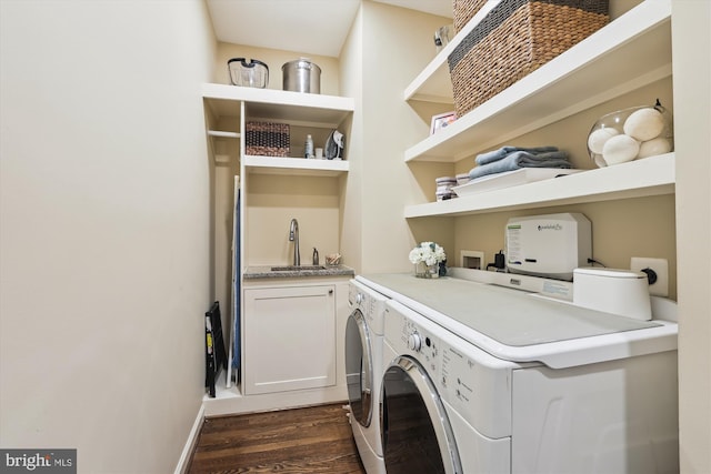 washroom featuring a sink, cabinet space, dark wood finished floors, and washer and clothes dryer