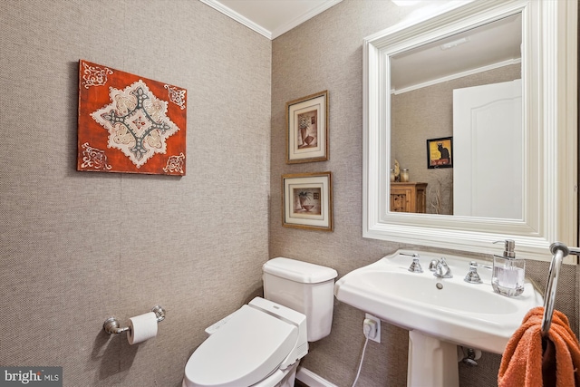 bathroom featuring a sink, toilet, and ornamental molding