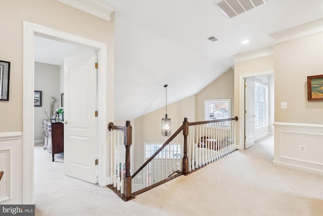 hall featuring visible vents, an upstairs landing, a notable chandelier, carpet, and crown molding