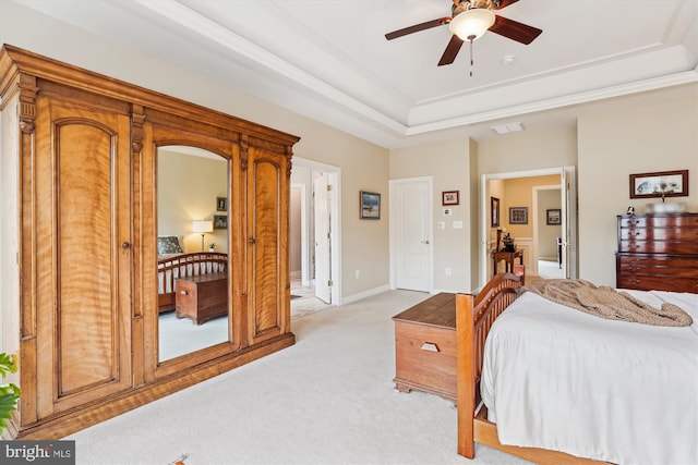 bedroom featuring visible vents, light carpet, a raised ceiling, crown molding, and baseboards