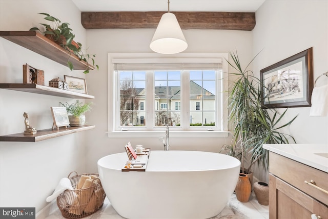 full bathroom featuring beamed ceiling, a soaking tub, and vanity