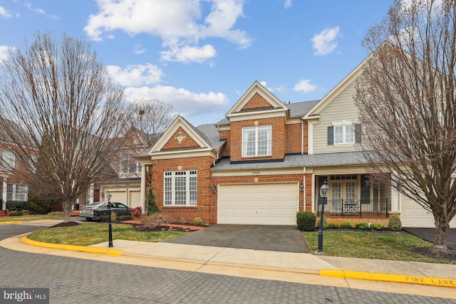 view of front facade featuring brick siding, a shingled roof, aphalt driveway, and a garage