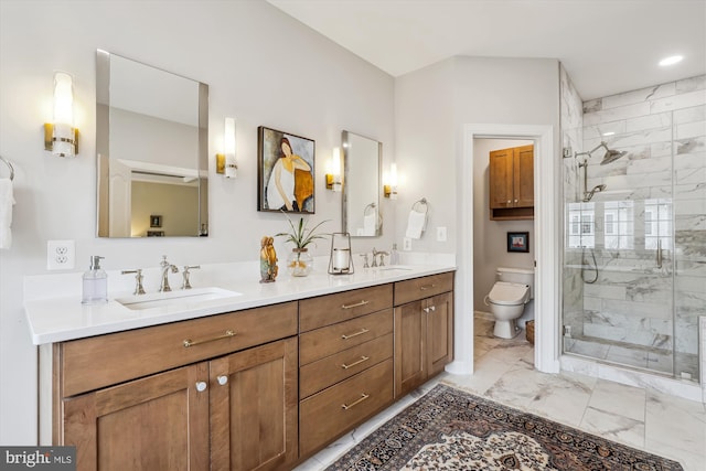 bathroom featuring toilet, marble finish floor, a sink, a shower stall, and double vanity