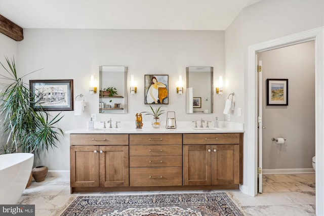 full bathroom with double vanity, marble finish floor, baseboards, and a sink