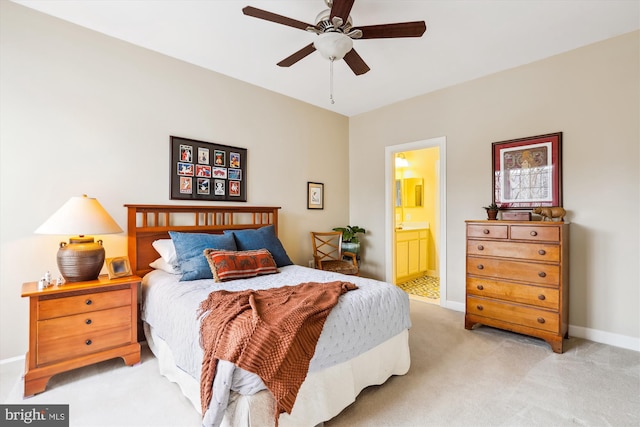 bedroom featuring baseboards, light carpet, a ceiling fan, and ensuite bathroom