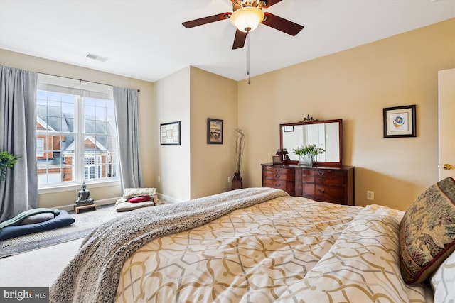 carpeted bedroom featuring visible vents, a ceiling fan, and baseboards