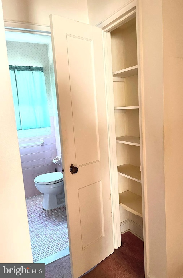 interior space featuring toilet and tile patterned flooring