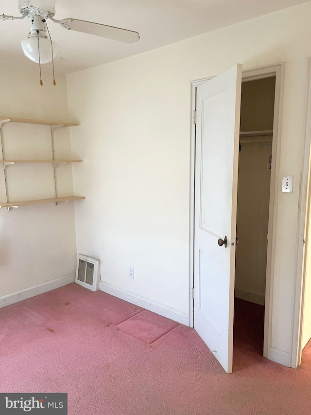 interior space featuring a closet, a walk in closet, and carpet flooring