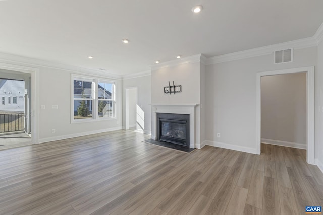 unfurnished living room with crown molding and light wood-type flooring