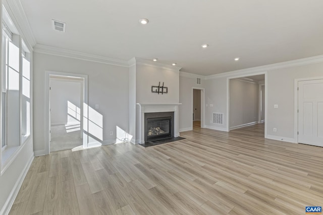 unfurnished living room featuring crown molding and light hardwood / wood-style floors