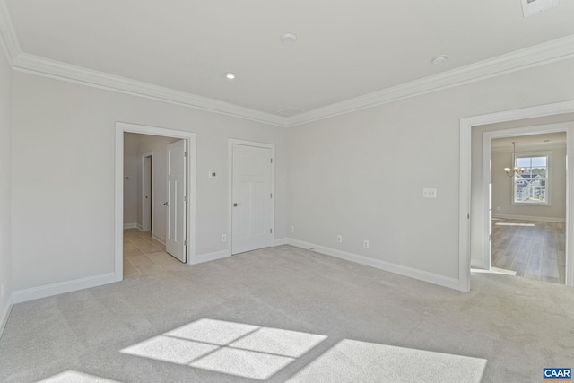 unfurnished bedroom with crown molding, light colored carpet, and a chandelier