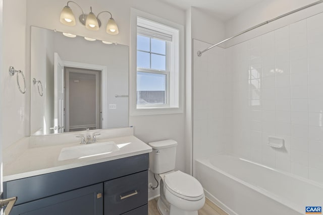 full bathroom featuring tiled shower / bath combo, vanity, and toilet