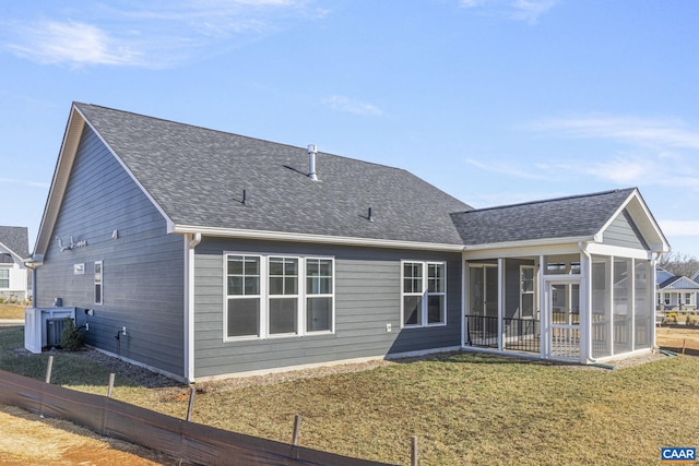 back of house featuring a yard, a sunroom, and central air condition unit