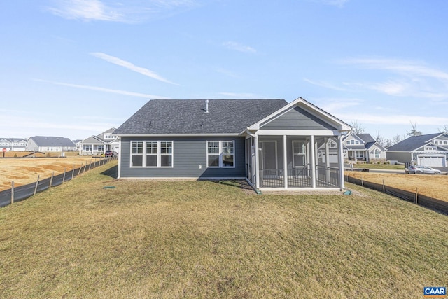 back of house featuring a lawn and a sunroom