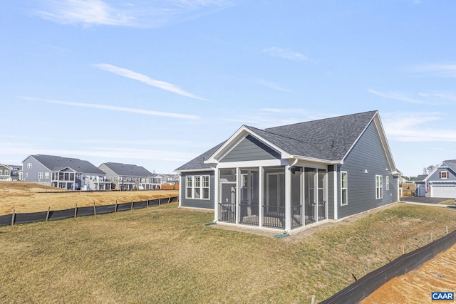 rear view of house with a lawn and a sunroom