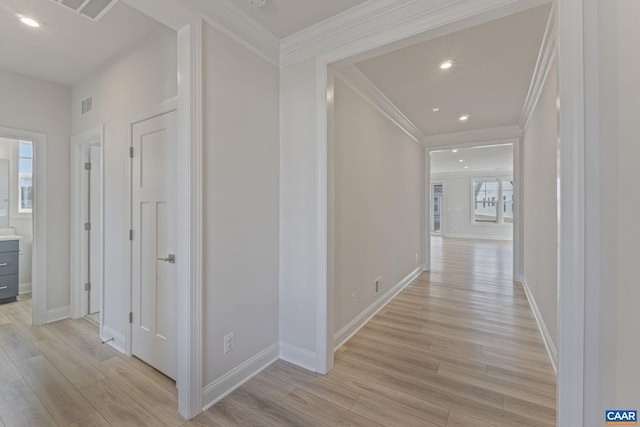 hall with crown molding and light hardwood / wood-style flooring