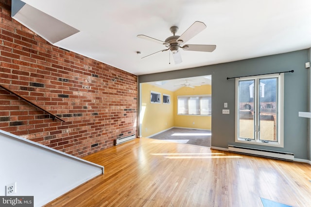 interior space with hardwood / wood-style flooring, a baseboard radiator, ceiling fan, and brick wall